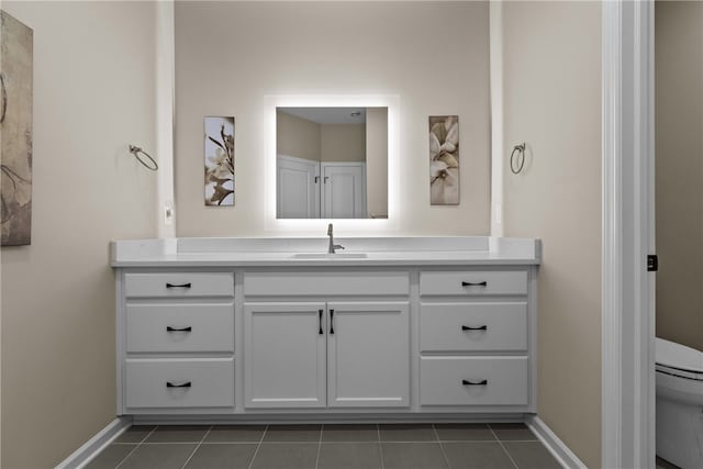 bathroom featuring tile patterned floors, vanity, and toilet