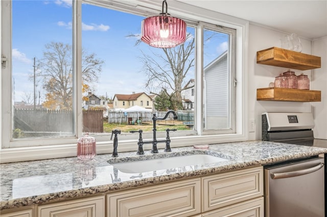 kitchen featuring cream cabinetry, appliances with stainless steel finishes, a wealth of natural light, and sink