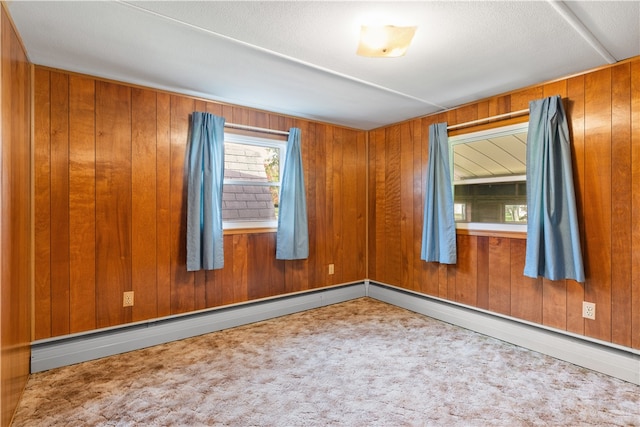 carpeted spare room featuring wooden walls