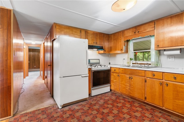 kitchen featuring sink, dark carpet, and white appliances