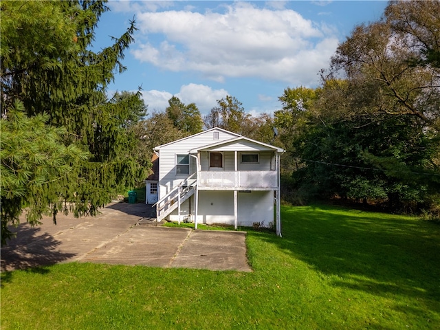 rear view of property with a yard and covered porch