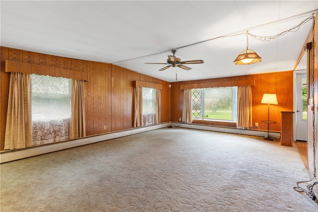 spare room with wood walls, lofted ceiling, a baseboard heating unit, ceiling fan, and carpet floors