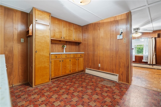 kitchen with ceiling fan, baseboard heating, and wood walls