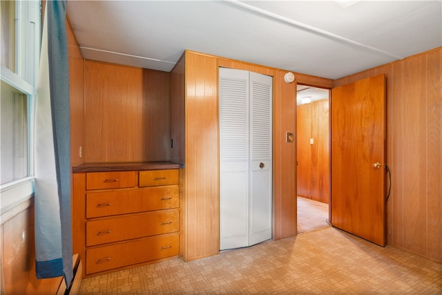 unfurnished bedroom with wooden walls and a closet