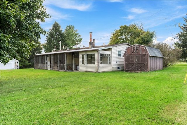 rear view of house featuring a yard and a storage shed