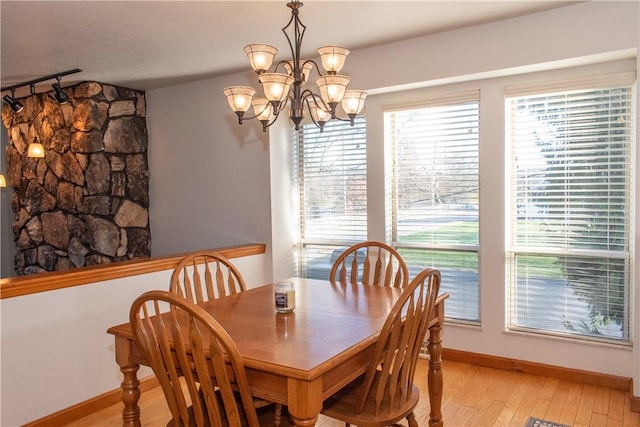 dining space with a chandelier and light wood-type flooring