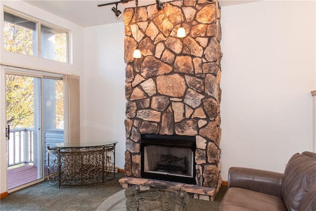 living room with carpet floors and a stone fireplace