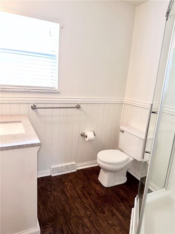 bathroom with vanity, hardwood / wood-style flooring, toilet, and a baseboard radiator