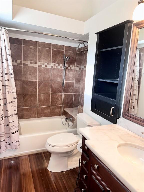 full bathroom featuring vanity, hardwood / wood-style flooring, toilet, and shower / bath combo with shower curtain