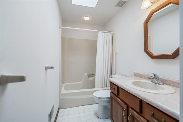 full bathroom with shower / bath combo, vanity, a skylight, and toilet