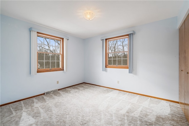 carpeted spare room with a healthy amount of sunlight