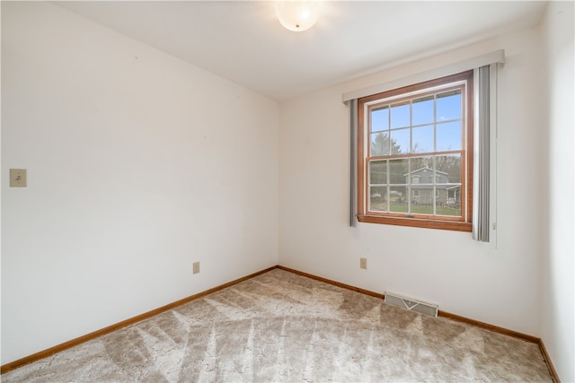 spare room featuring light colored carpet