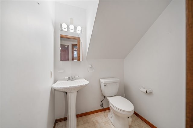 bathroom with lofted ceiling and toilet