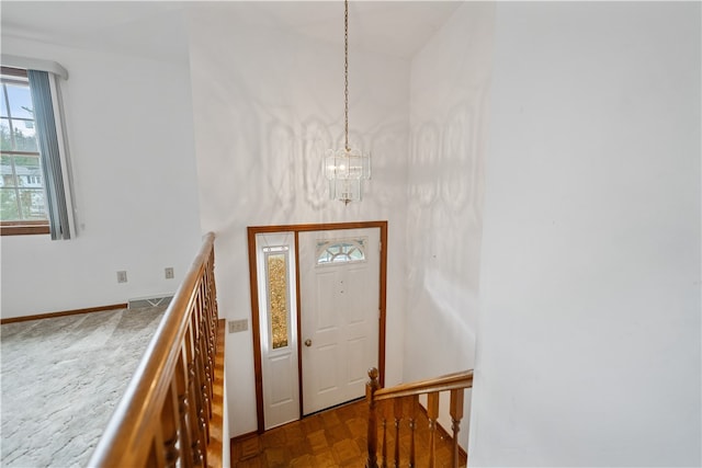 foyer entrance featuring light parquet flooring and an inviting chandelier