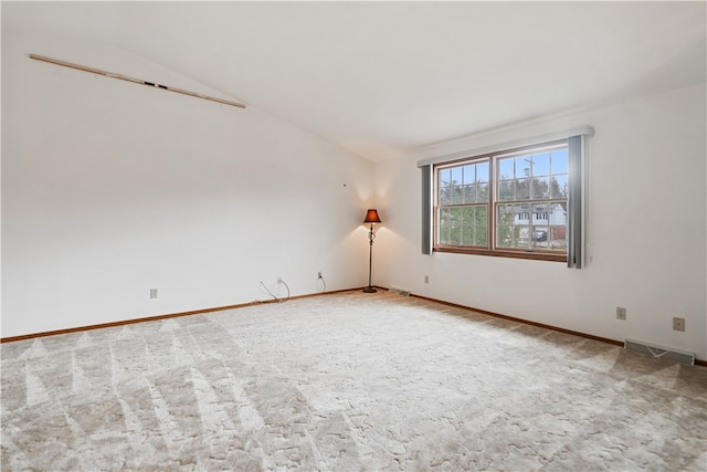 empty room with carpet flooring and lofted ceiling