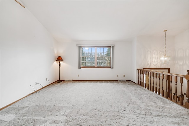 unfurnished room featuring carpet flooring and a chandelier