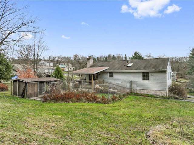 rear view of property featuring a yard and an outdoor structure