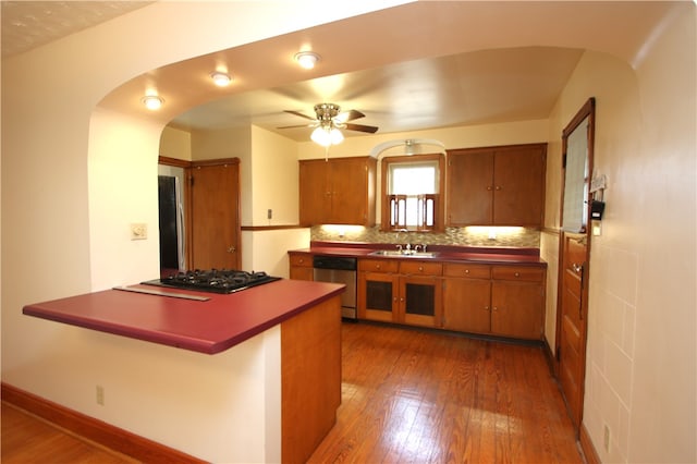 kitchen featuring decorative backsplash, black gas stovetop, ceiling fan, dishwasher, and dark hardwood / wood-style floors