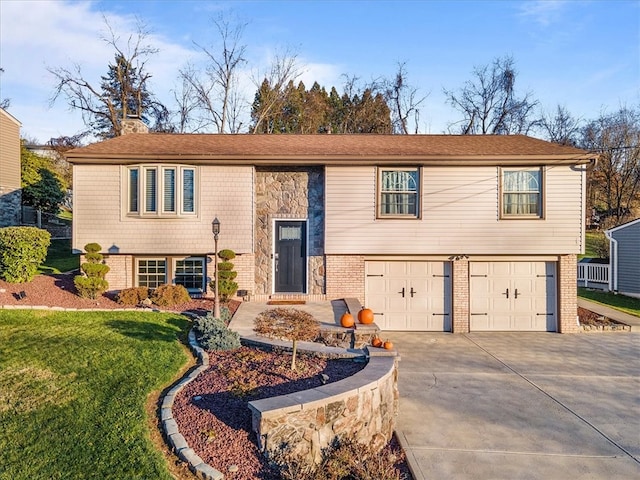 raised ranch featuring a garage and a front yard