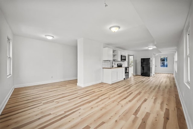 unfurnished living room with light wood-type flooring and sink