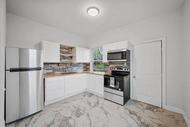 810 Hays St, Homestead, PA 15120 - kitchen featuring appliances with stainless steel finishes, light marble finish floors, white cabinetry, and open shelves