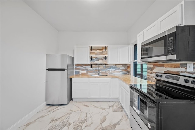 kitchen featuring tasteful backsplash, sink, white cabinets, and appliances with stainless steel finishes