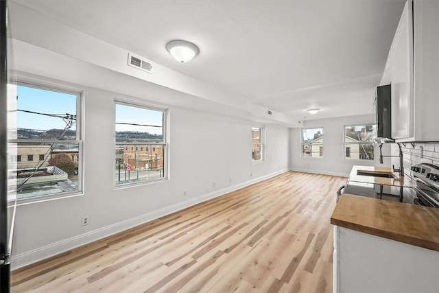 living room with a fireplace, sink, plenty of natural light, and light wood-type flooring