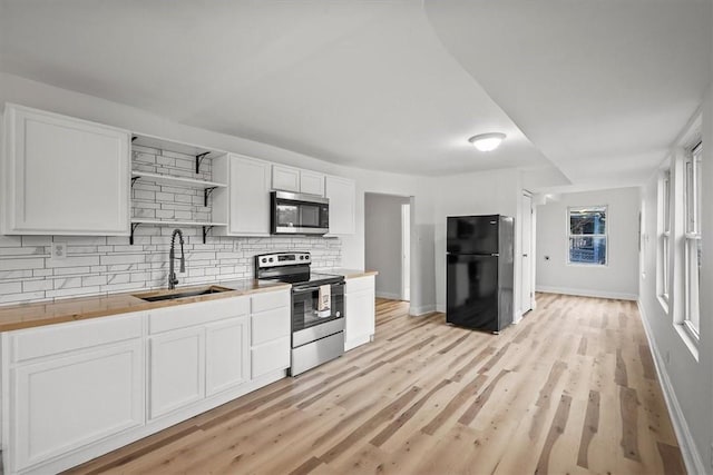 810 Hays St, Homestead, PA 15120 - kitchen featuring stainless steel appliances, decorative backsplash, open shelves, white cabinetry, and light wood-style floors
