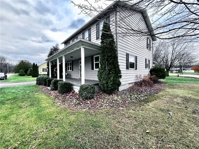 view of home's exterior featuring a porch and a yard