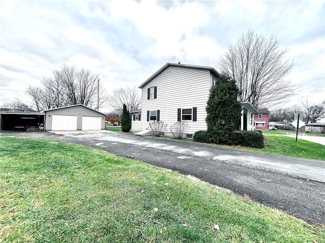 view of side of home with a lawn, a garage, and an outdoor structure