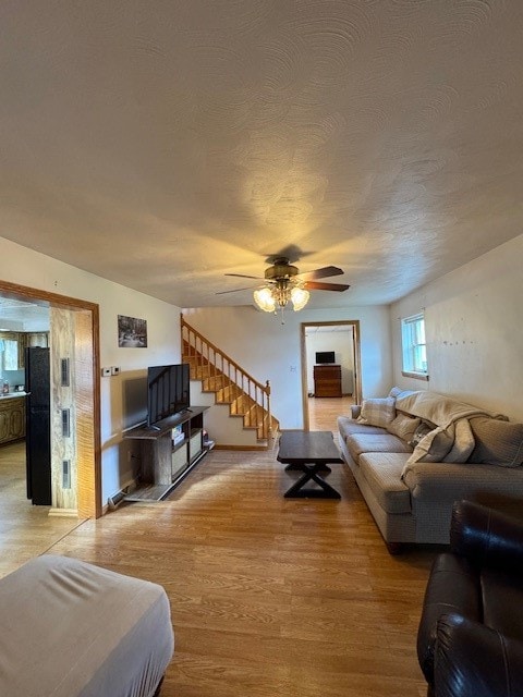 living room with light hardwood / wood-style flooring and ceiling fan