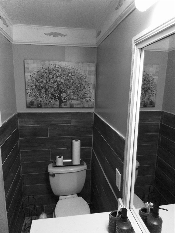 bathroom featuring tile walls and toilet