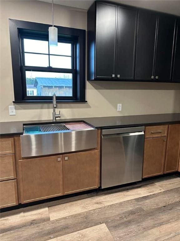 kitchen featuring dishwasher, pendant lighting, light hardwood / wood-style floors, and sink