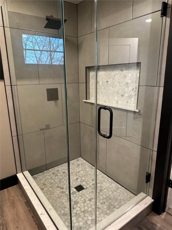 bathroom featuring wood-type flooring and a shower with door