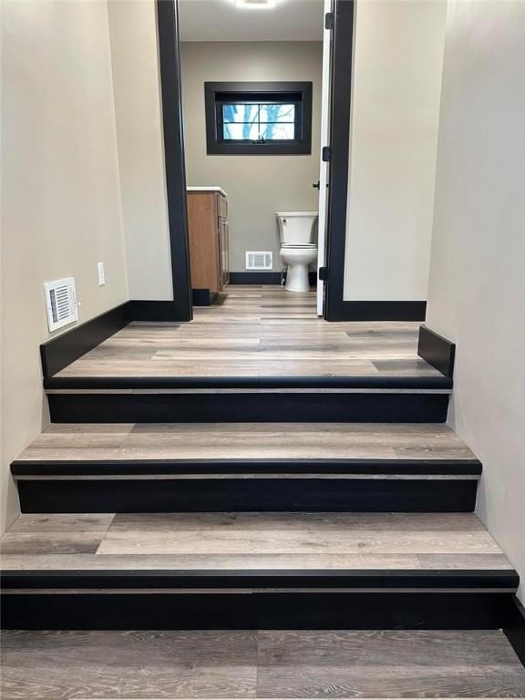 stairway with hardwood / wood-style floors