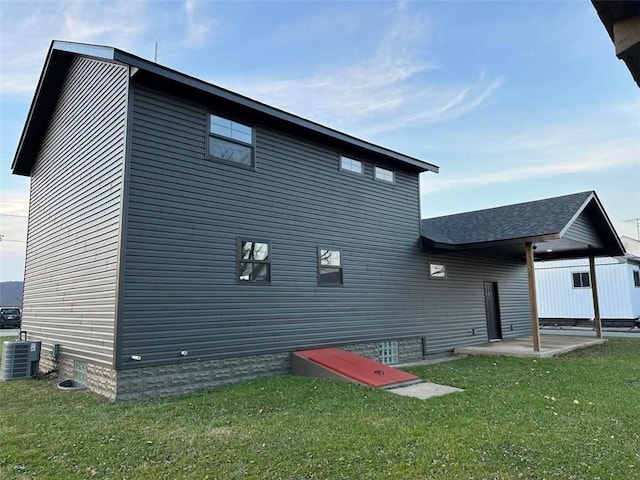 rear view of house with a lawn and cooling unit