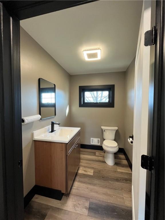 bathroom with vanity, hardwood / wood-style flooring, and toilet