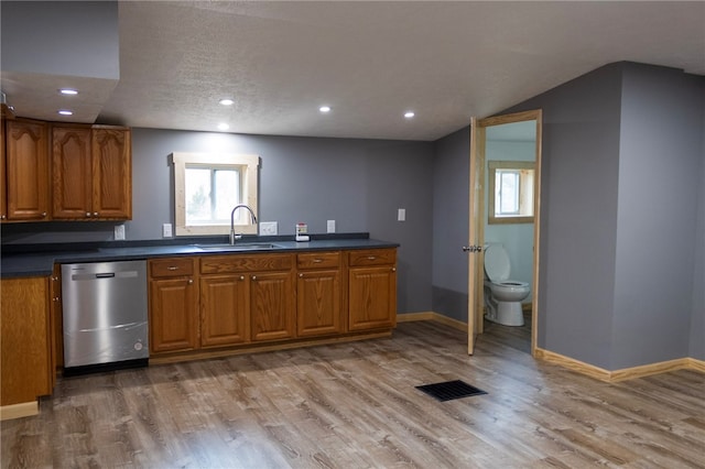 kitchen featuring dishwasher, hardwood / wood-style floors, a textured ceiling, and sink