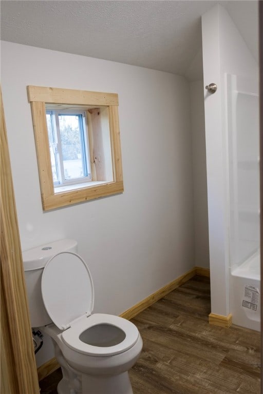 bathroom featuring hardwood / wood-style flooring, toilet, and a textured ceiling