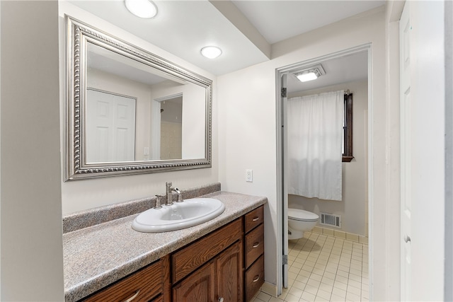 bathroom with tile patterned flooring, vanity, and toilet