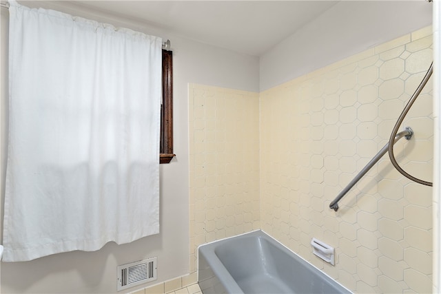 bathroom with tile patterned flooring and tiled shower / bath