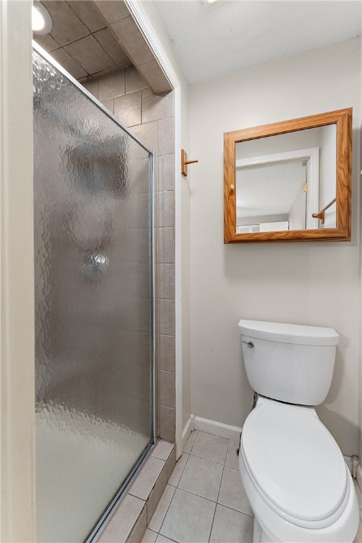 bathroom featuring toilet, tile patterned floors, and a shower with door