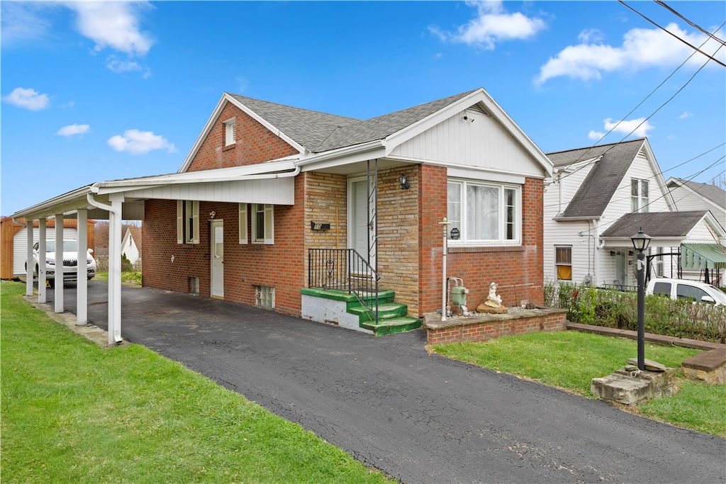 view of front of home with a front yard and a carport