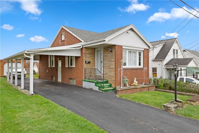 view of front of home with a front yard and a carport