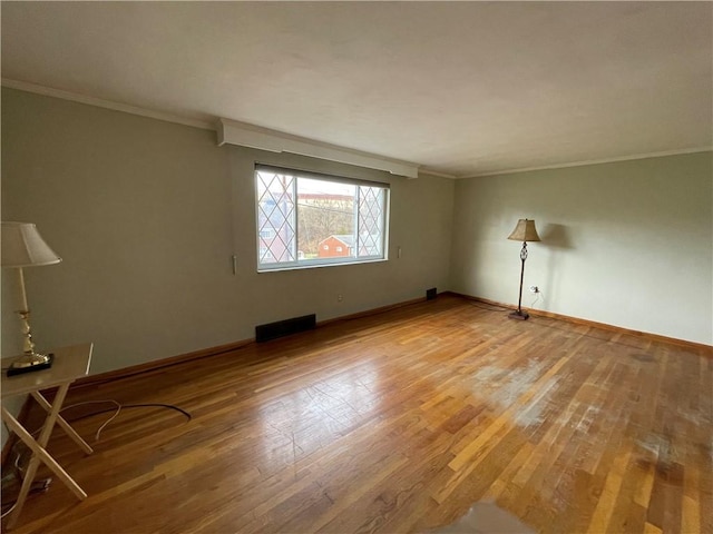 empty room with wood-type flooring and ornamental molding