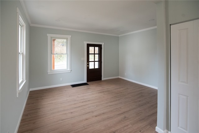 foyer entrance with crown molding and light hardwood / wood-style flooring