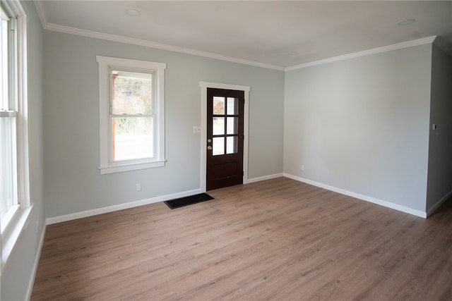 foyer with light wood-type flooring and crown molding