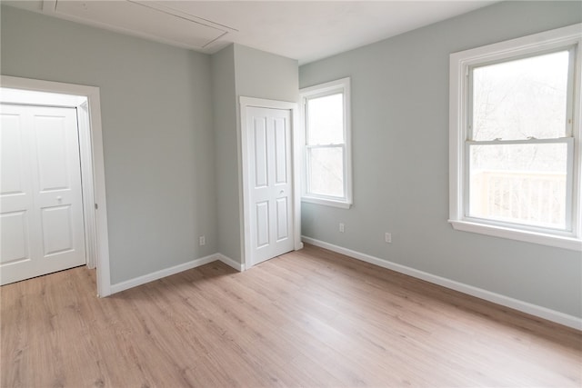 unfurnished bedroom with multiple windows and light wood-type flooring