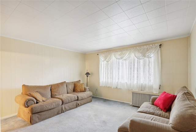 living room with crown molding, radiator heating unit, and light carpet