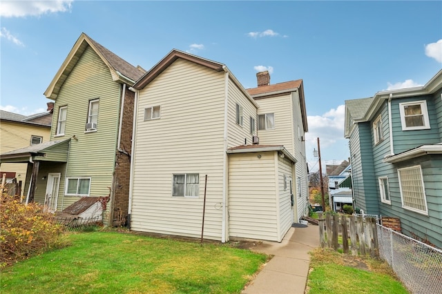 rear view of house featuring a yard